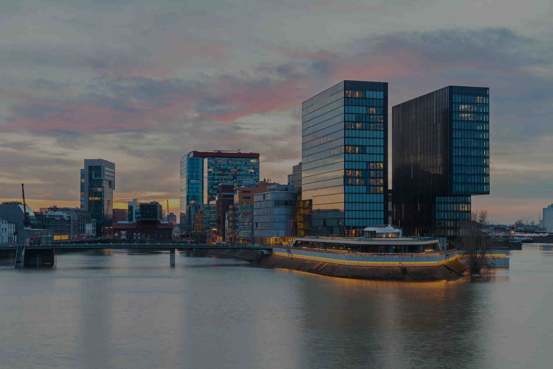 A city with tall buildings and a river in the background.