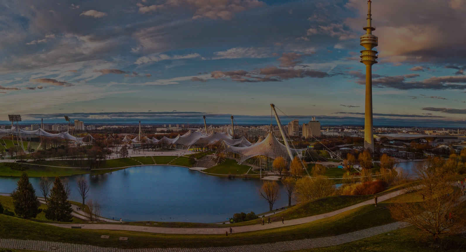 A panoramic view of a city with a serene lake in the background.