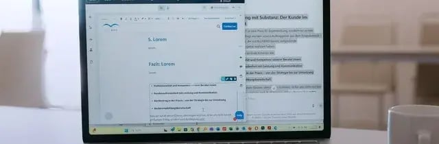 Laptop mit BLUEBIRD-Fachinhalten auf einem Besprechungstisch